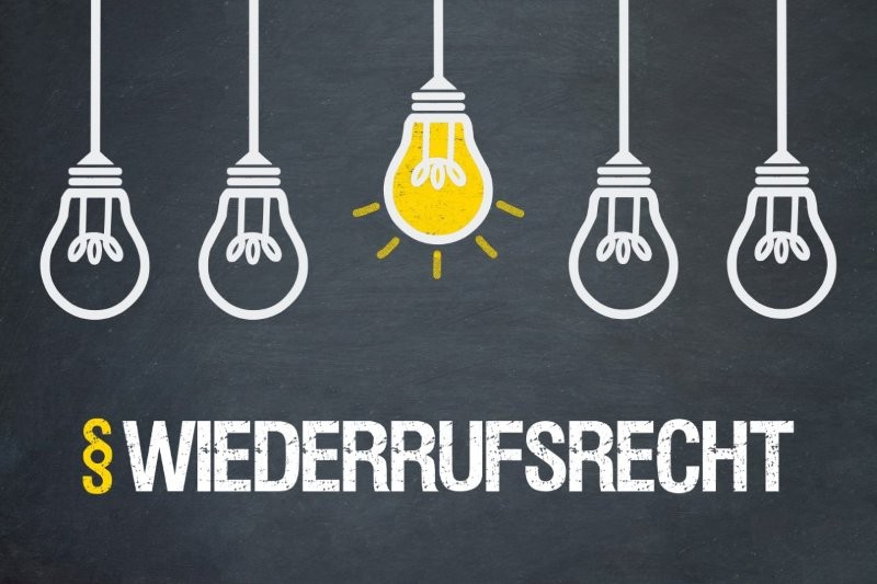 Aufschrift ‚Widerrufsrecht‘ mit Paragrafenzeichen und Glühlampen, von denen eine leuchtet