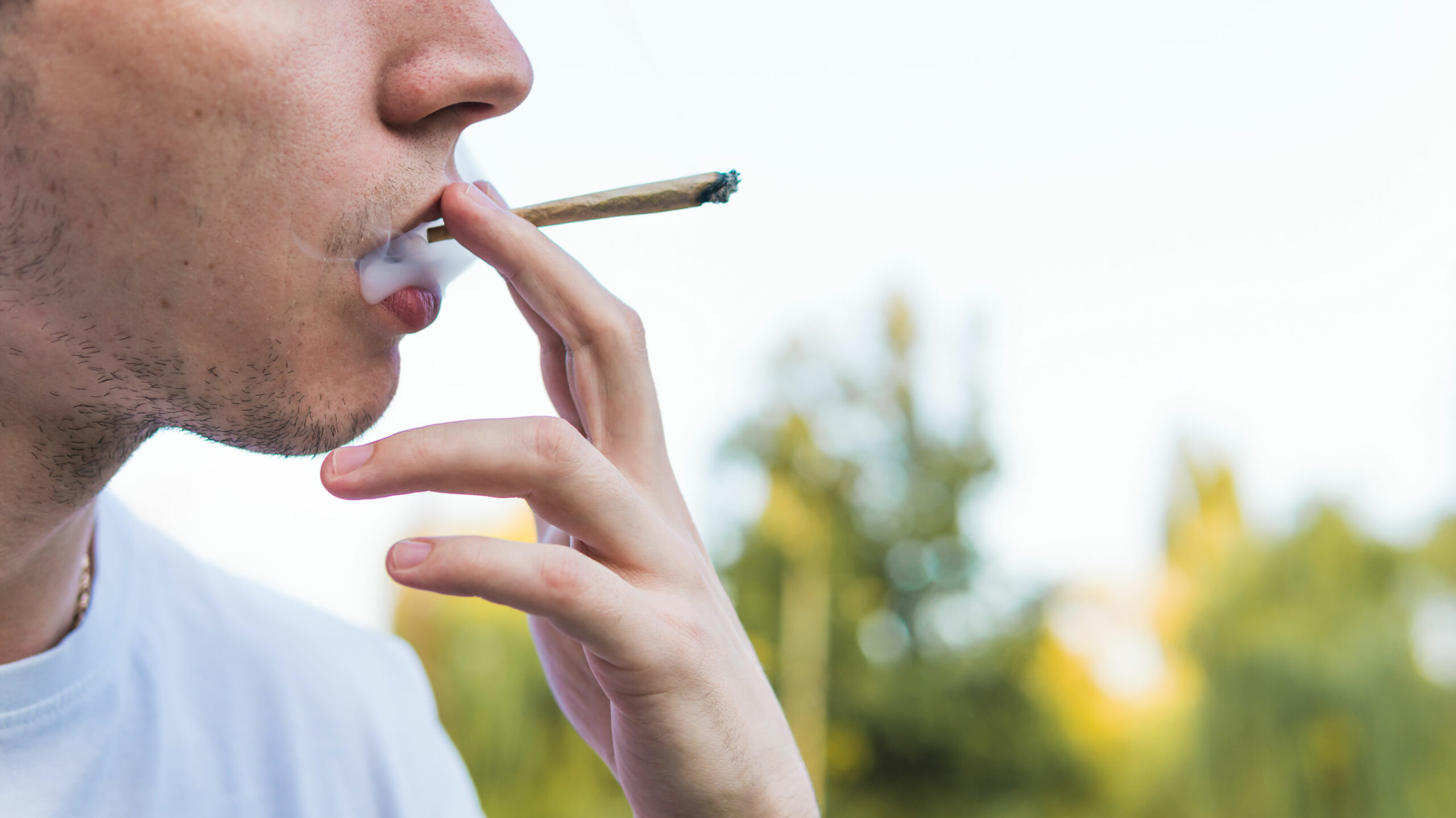 Un homme fume un joint de cannabis
