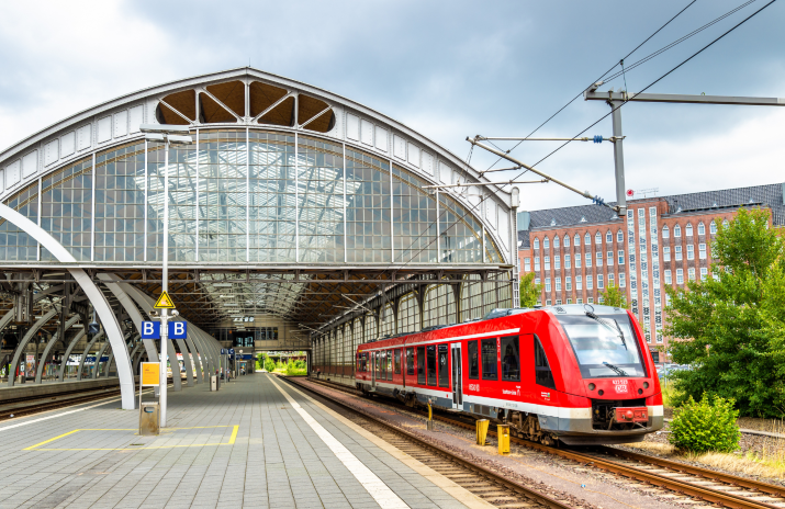 Ein roter Regionalexpress der Deutschen Bahn steht an einem Bahnhof.