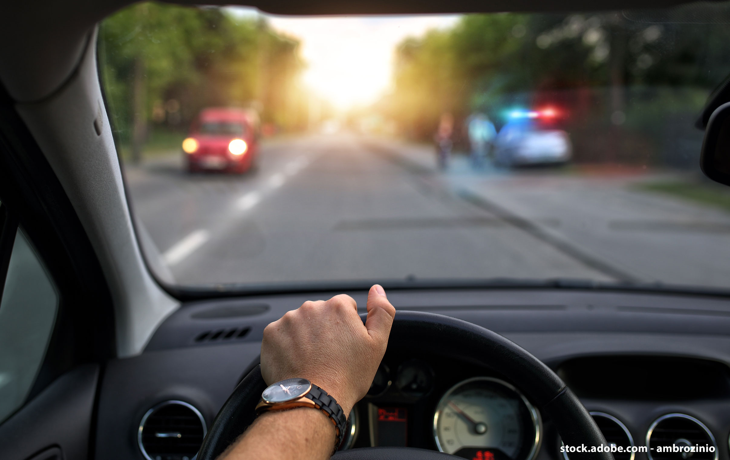 Véhicule qui circule sur une route avec un contrôle de police à quelques mètres