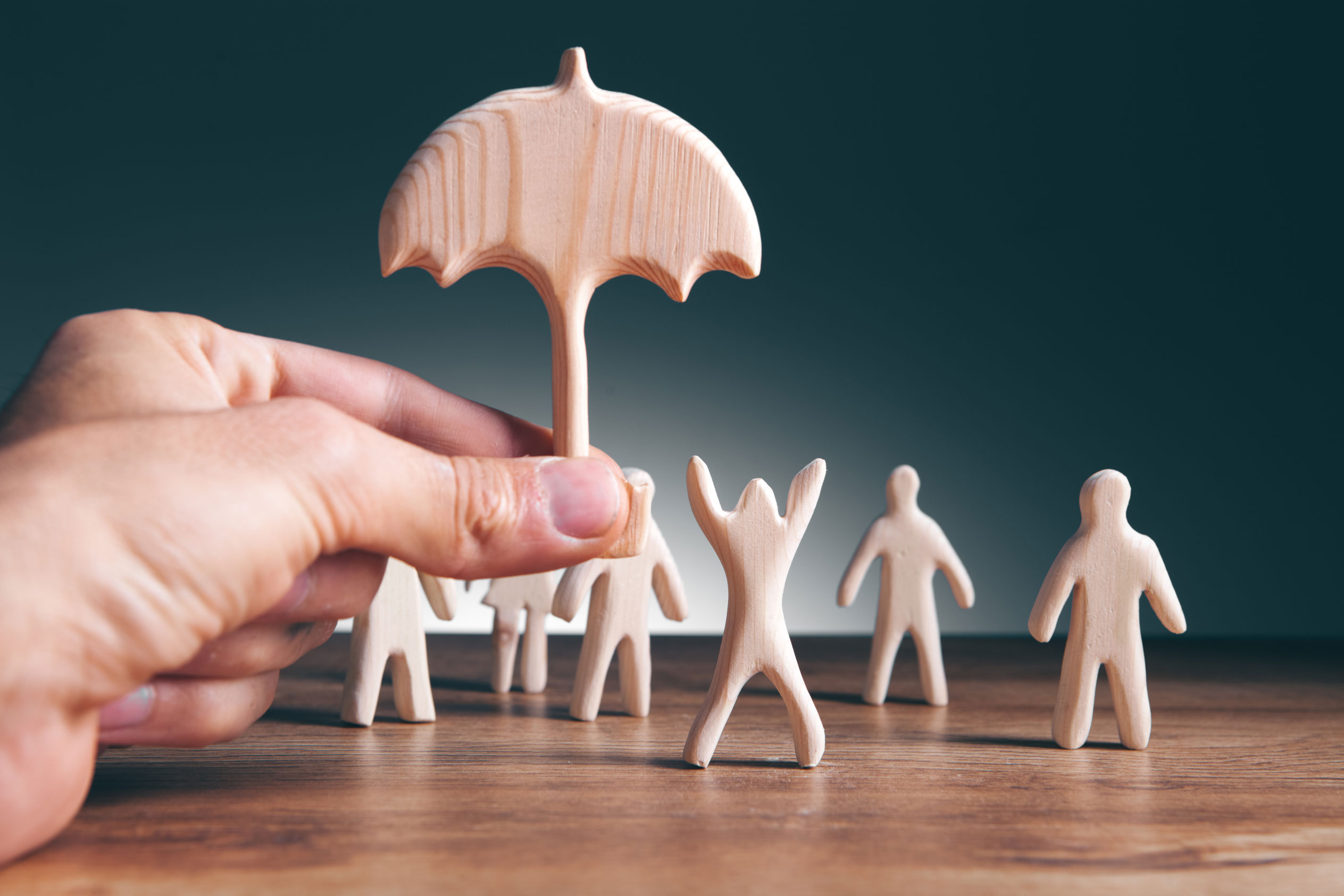 Un parapluie en bois protège des personnages afin d'illustrer le but des assurances