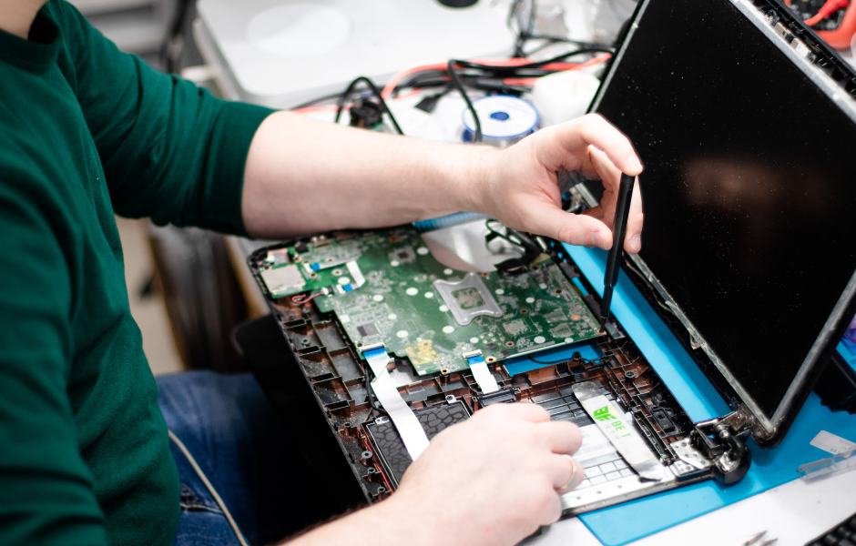 Ein aufgeschraubter Laptop wird repariert.