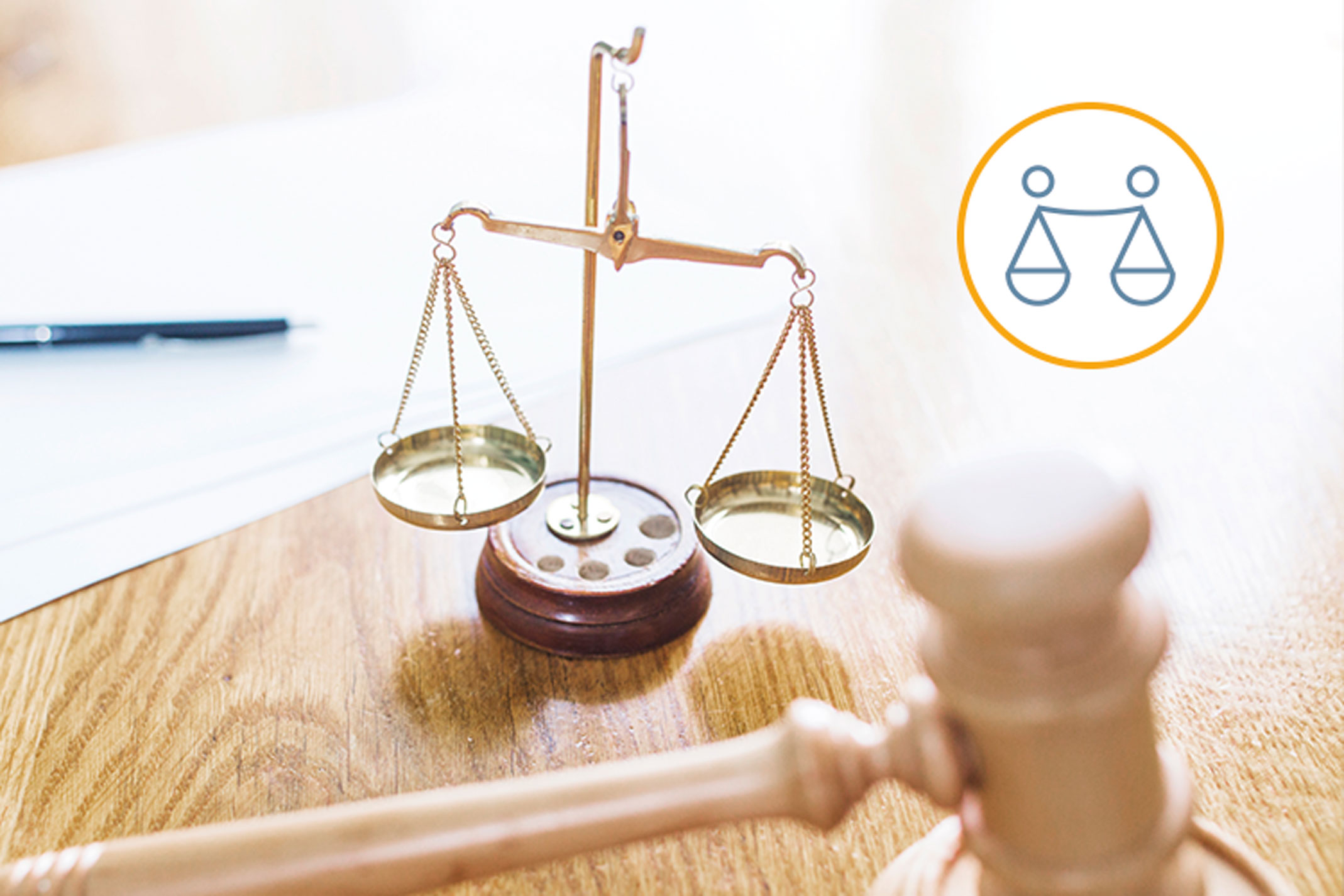 Hammer und Waage als Symbole der Justiz stehen auf einem Tisch.